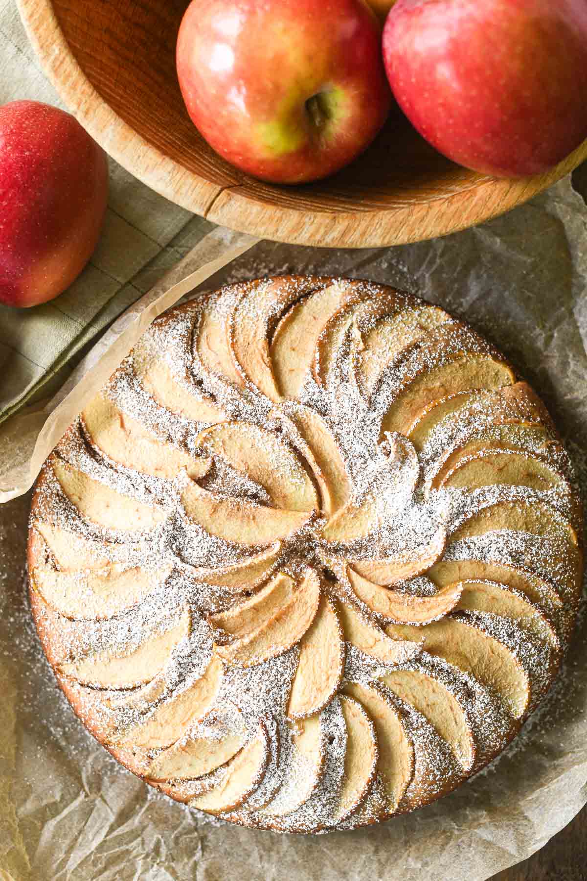 apple cinnamon cake with bowl of apples.