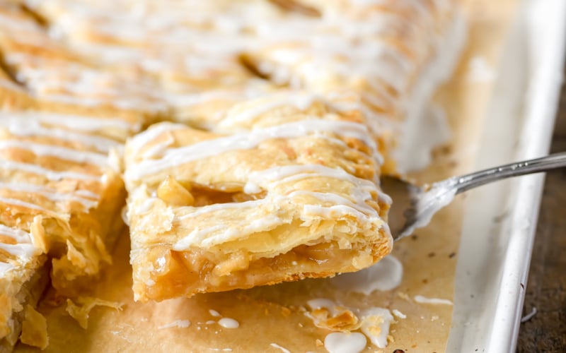 Taking a slice of puff pastry apple strudel.