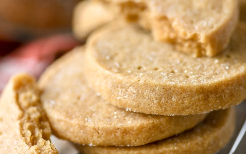 Brown sugar shortbread cookies, stacked with one broken apart to show texture.
