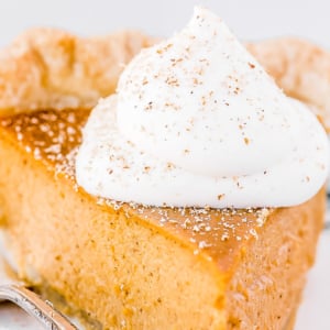 Slice of pumpkin pie with whipped cream.