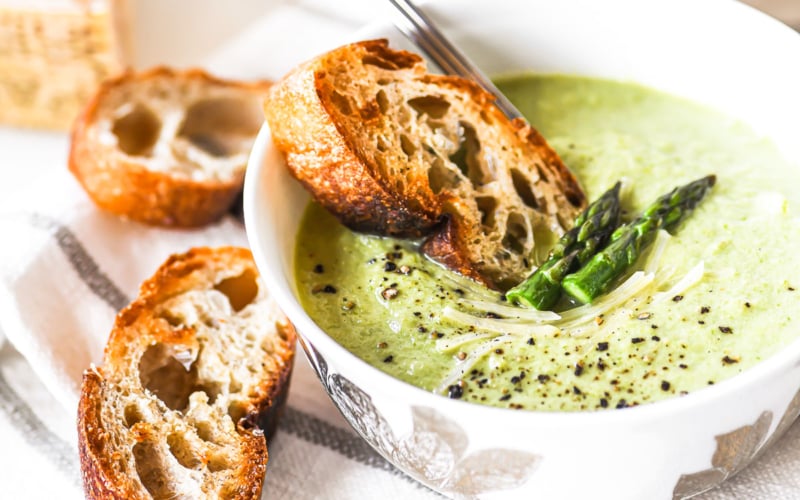 asparagus bisque in a small bowl with croutons.