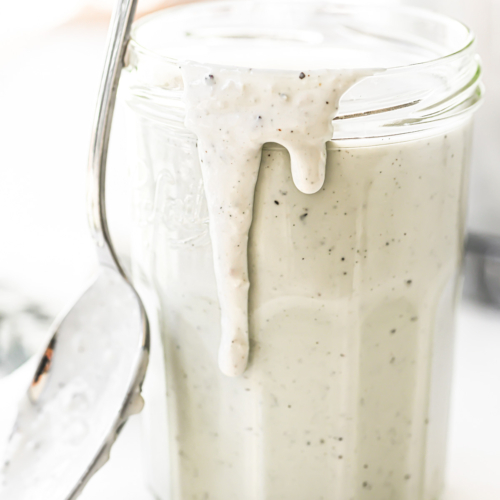 A jar of Gorgonzola dressing with spoon.