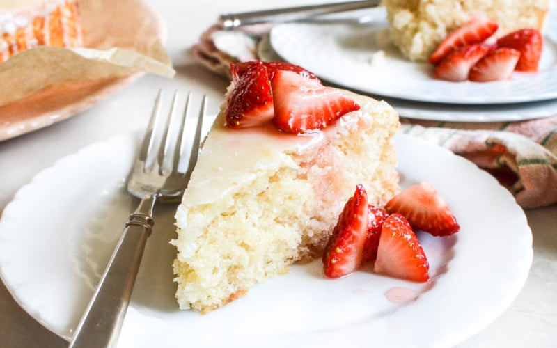 a slice of vegan lemon cake topped with strawberries.