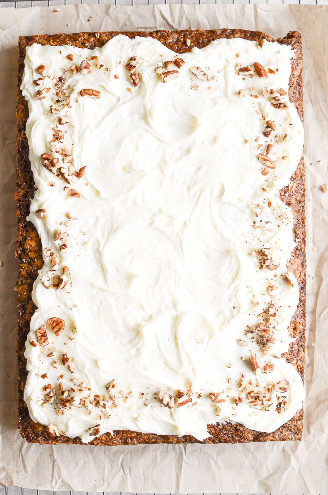 Carrot sheet cake with frosting and chopped pecans.