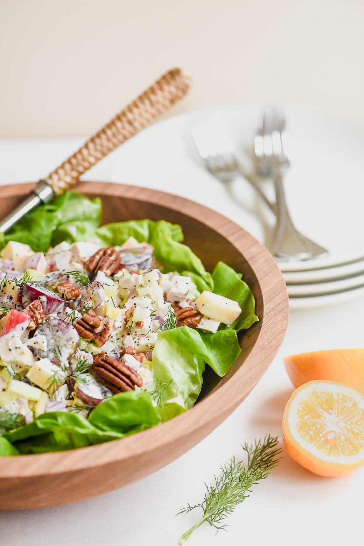 Sonoma chicken salad in a wooden bowl with Meyer lemons.