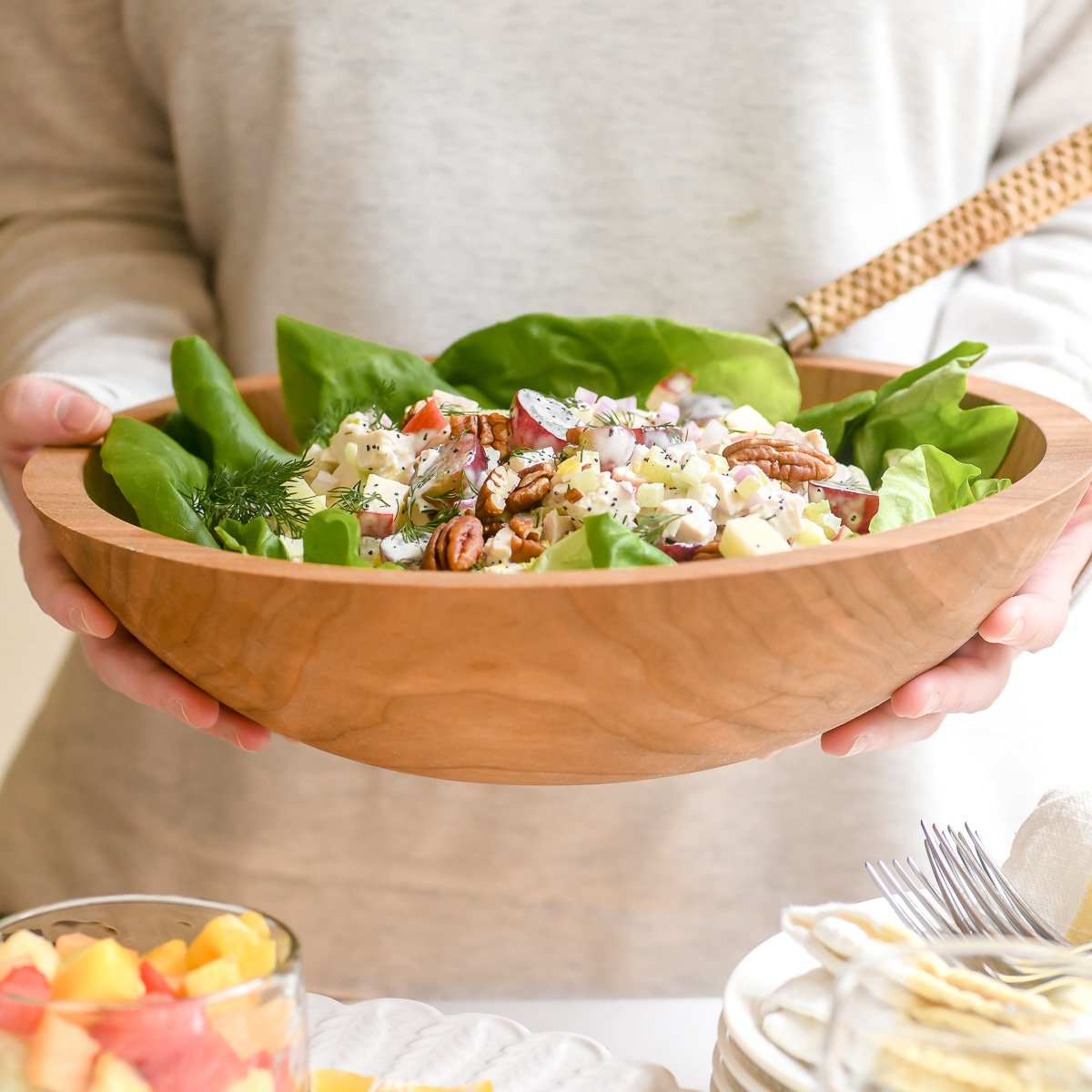 holding a serving bowl of Sonoma chicken salad with Bibb lettuce.
