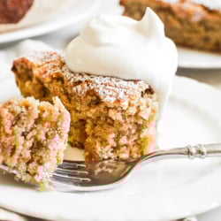 taking a bite of a slice of almond flour banana cake, topped with whipped cream.