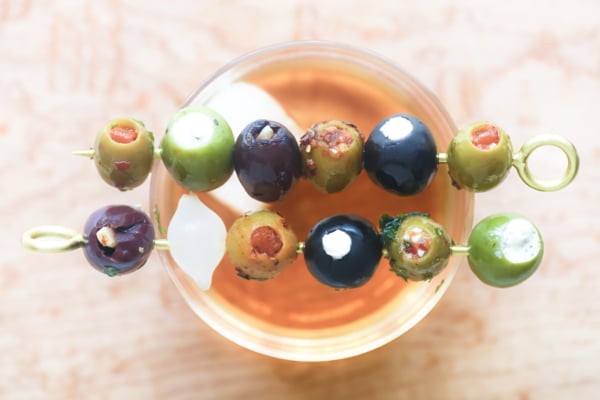 stuffed olive cocktail picks on a cocktail glass.