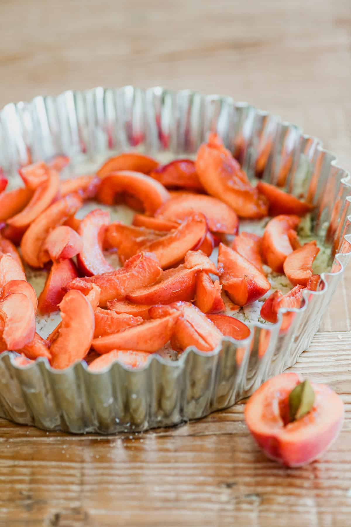 sliced apricots in a tart pan.