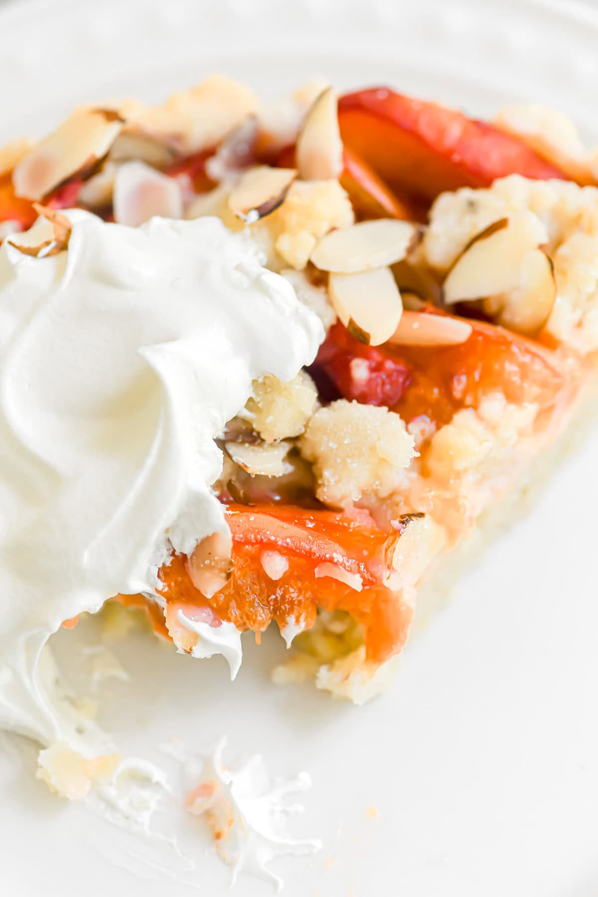 a slice of apricot almond tart with bite taken.