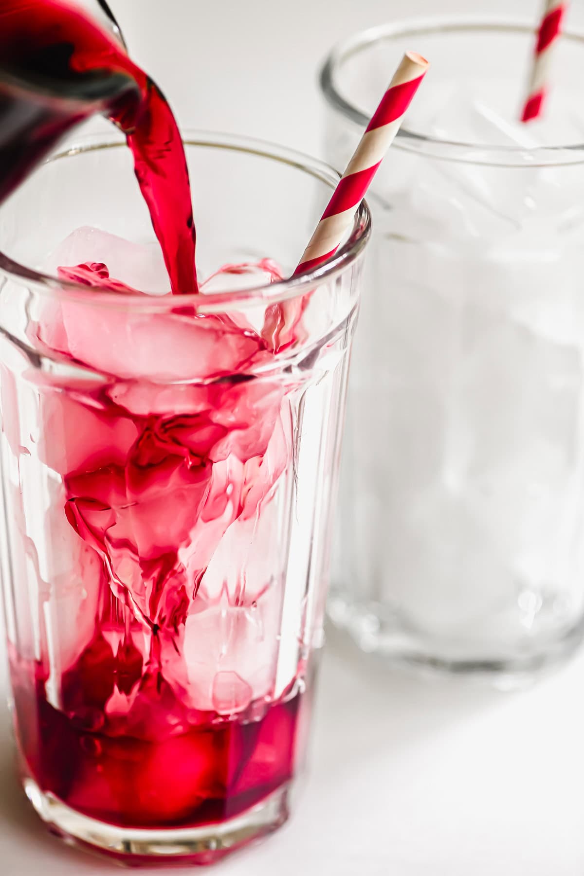 pouring hibiscus tea over ice.