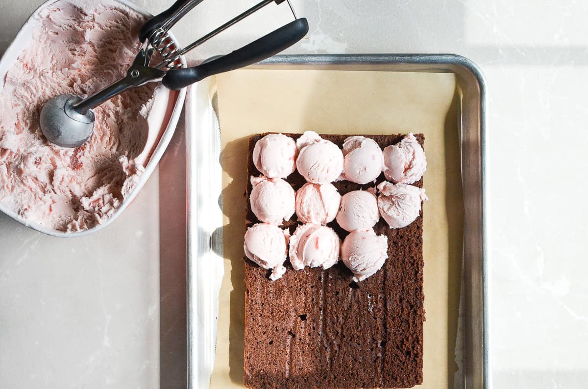 Scooping ice cream onto a brownie for ice cream sandwiches.