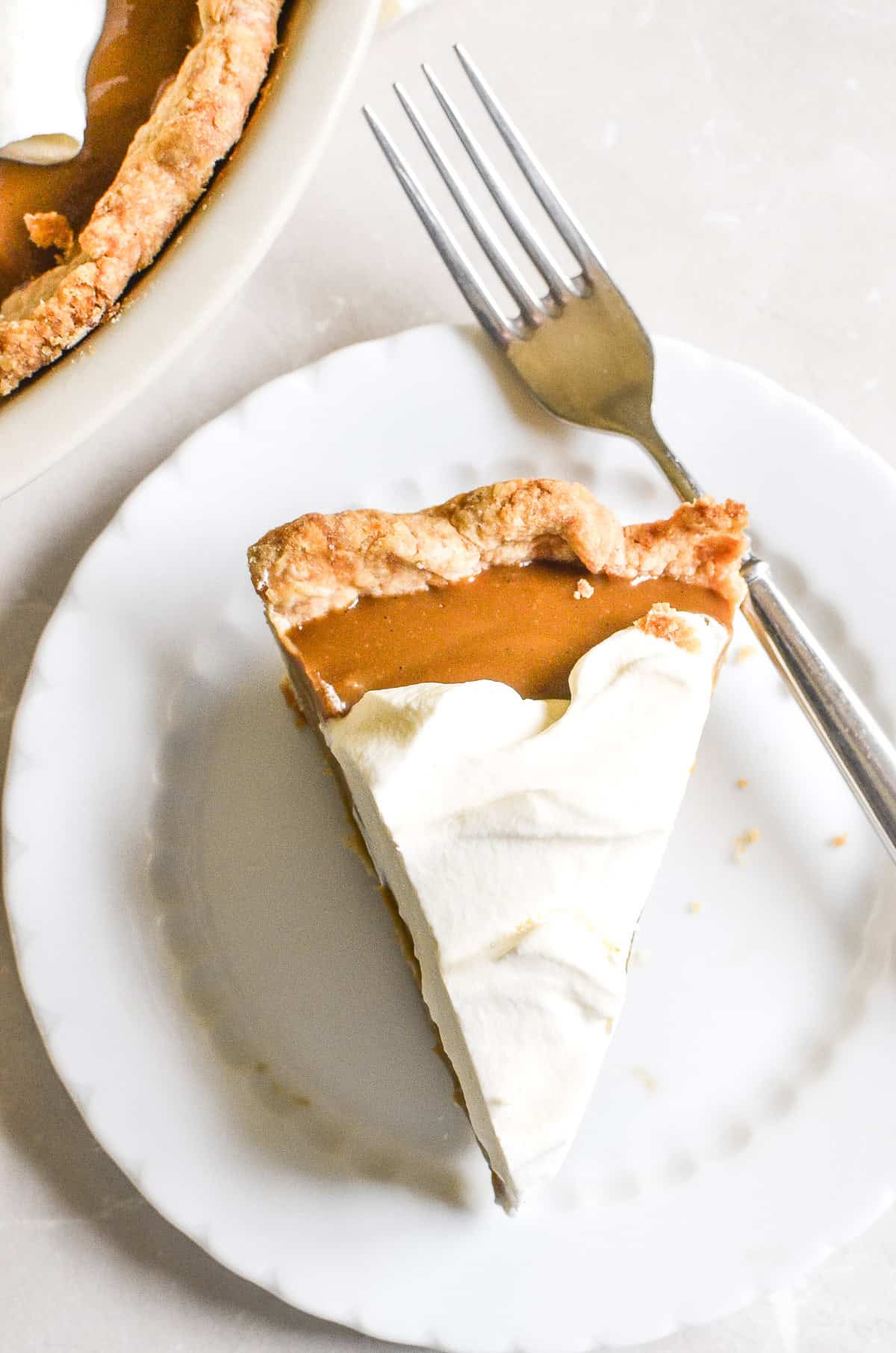 A slice of butterscotch pudding pie on a white plate with a fork.