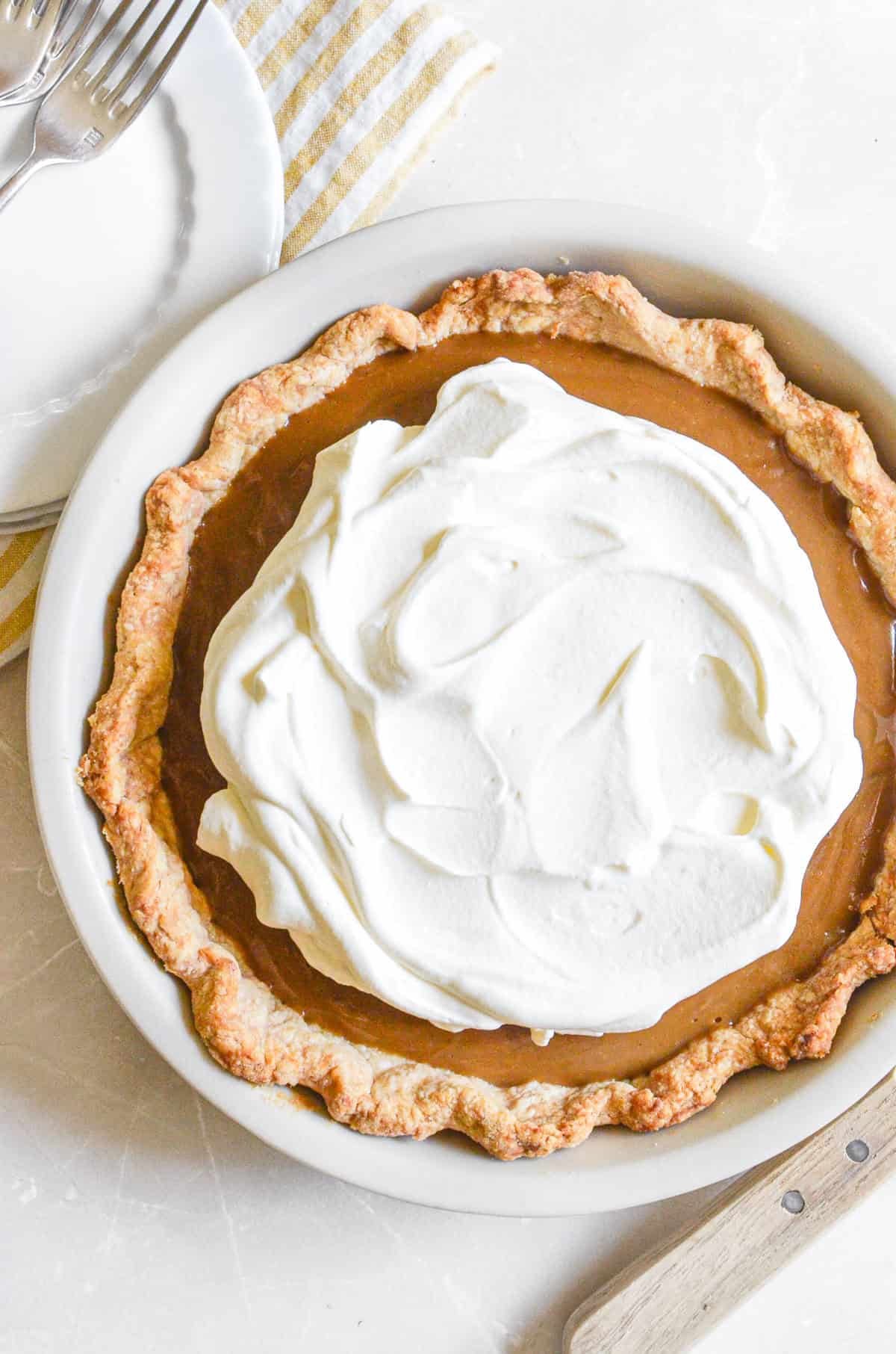 Butterscotch pudding pie topped with whipped cream.