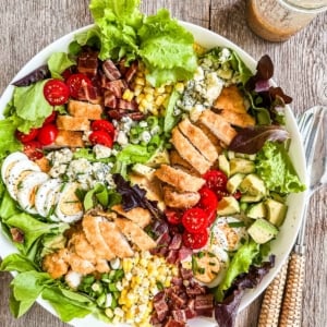 fried chicken cobb salad composed in a white bowl.