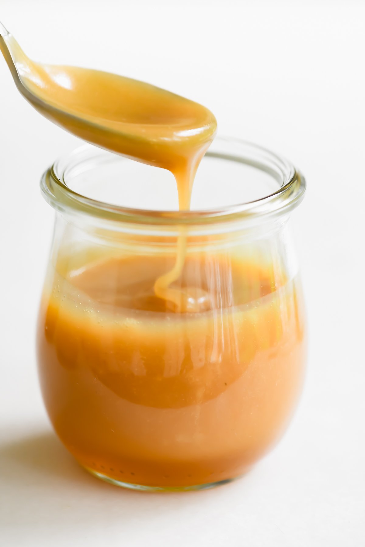 honey caramel sauce with spoon and jar.