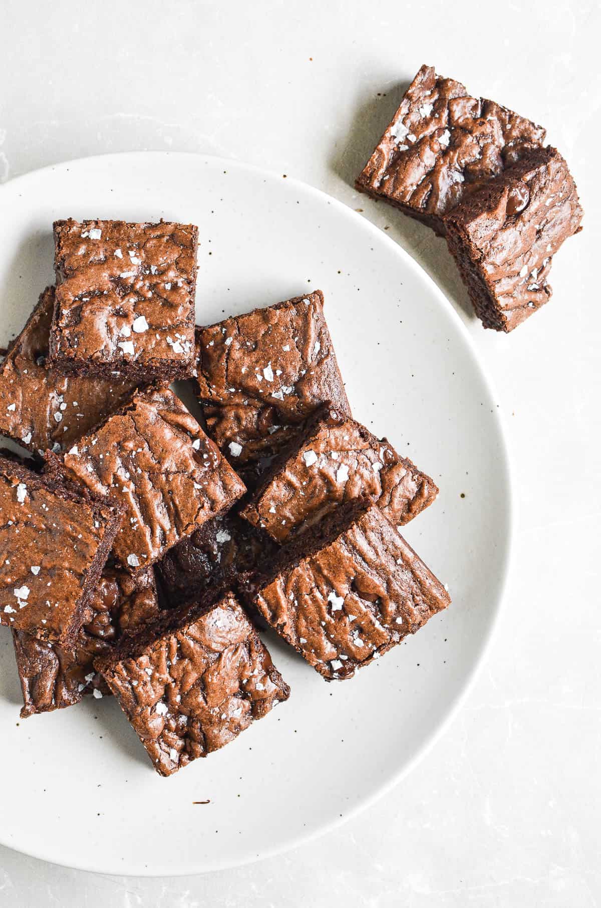 a plate of olive oil brownies topped with flaky salt.