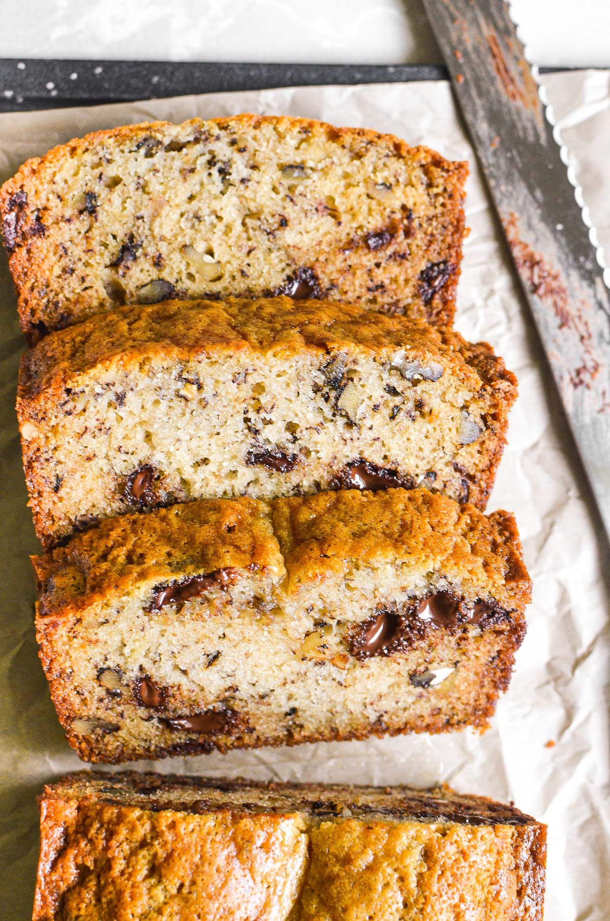 One Banana Banana Bread with Chocolate Chips and Walnuts ~ when there's just one banana left on the counter! #easy #recipe #bananas #bananabread #chocolatechipbananabread #quickbread #loafcake #bananacake #cake #breakfast #brunch A loaf of banana bread, sliced.