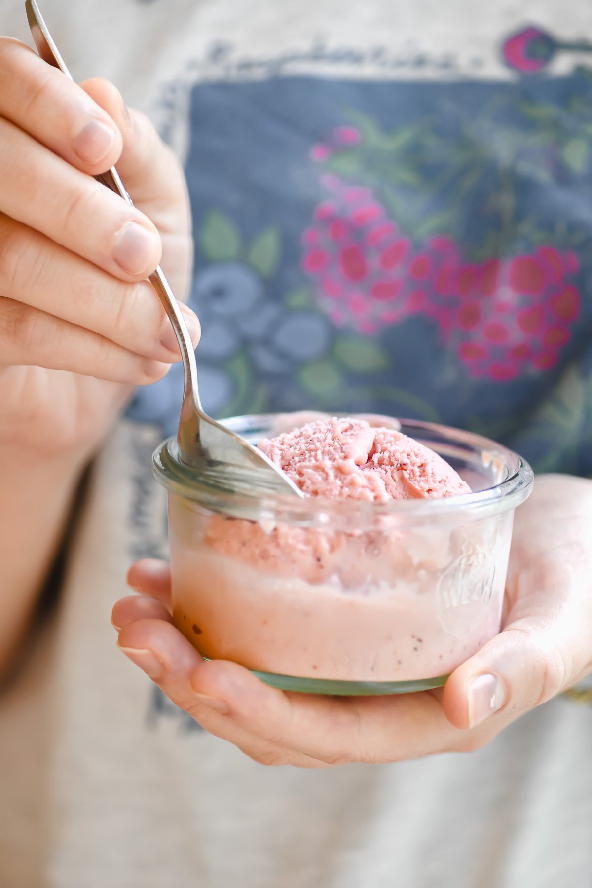 taking a bite of strawberry buttermilk ice cream, in a small glass