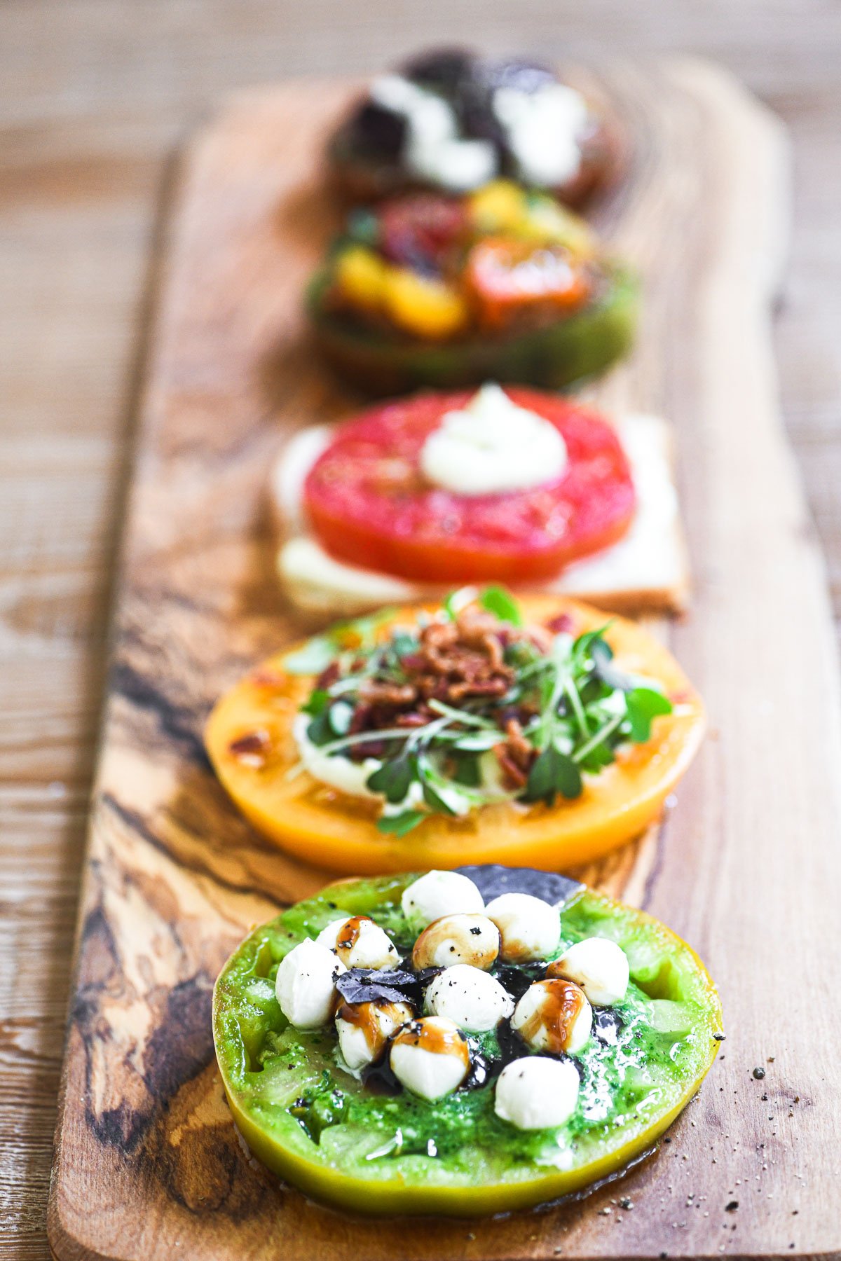Colorful tomato flights on a long wooden platter.