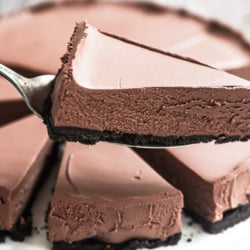 Taking a slice of no bake chocolate cheesecake with cake server.