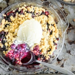 blackberry crisp in a small pie plate, on a baking sheet.