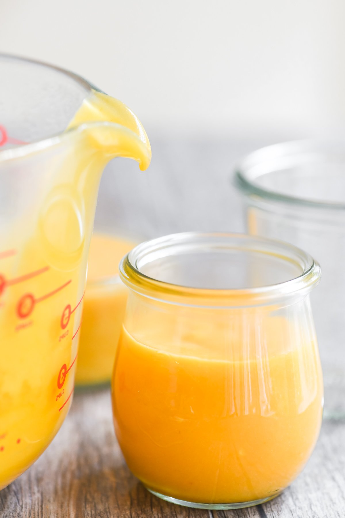 Filling small jars with apricot curd.