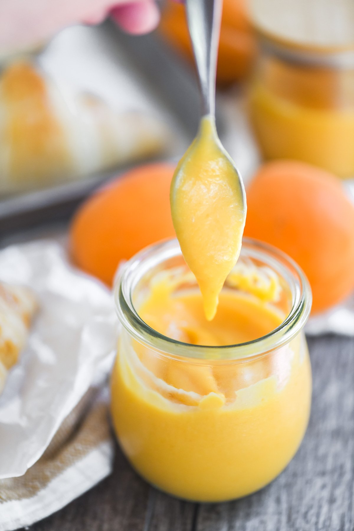 apricot curd dripping from small spoon.