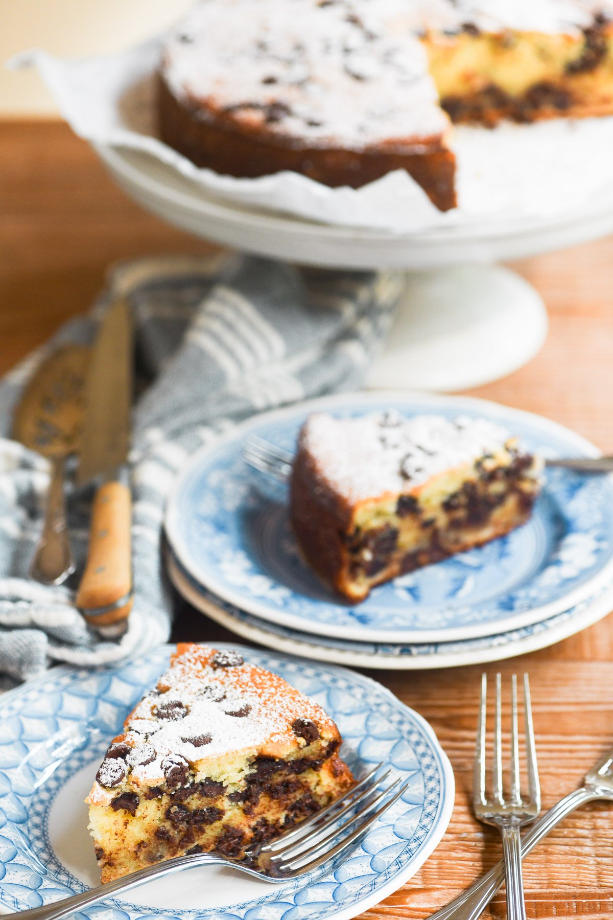 serving Italian chocolate chip ricotta cake on a wooden table.