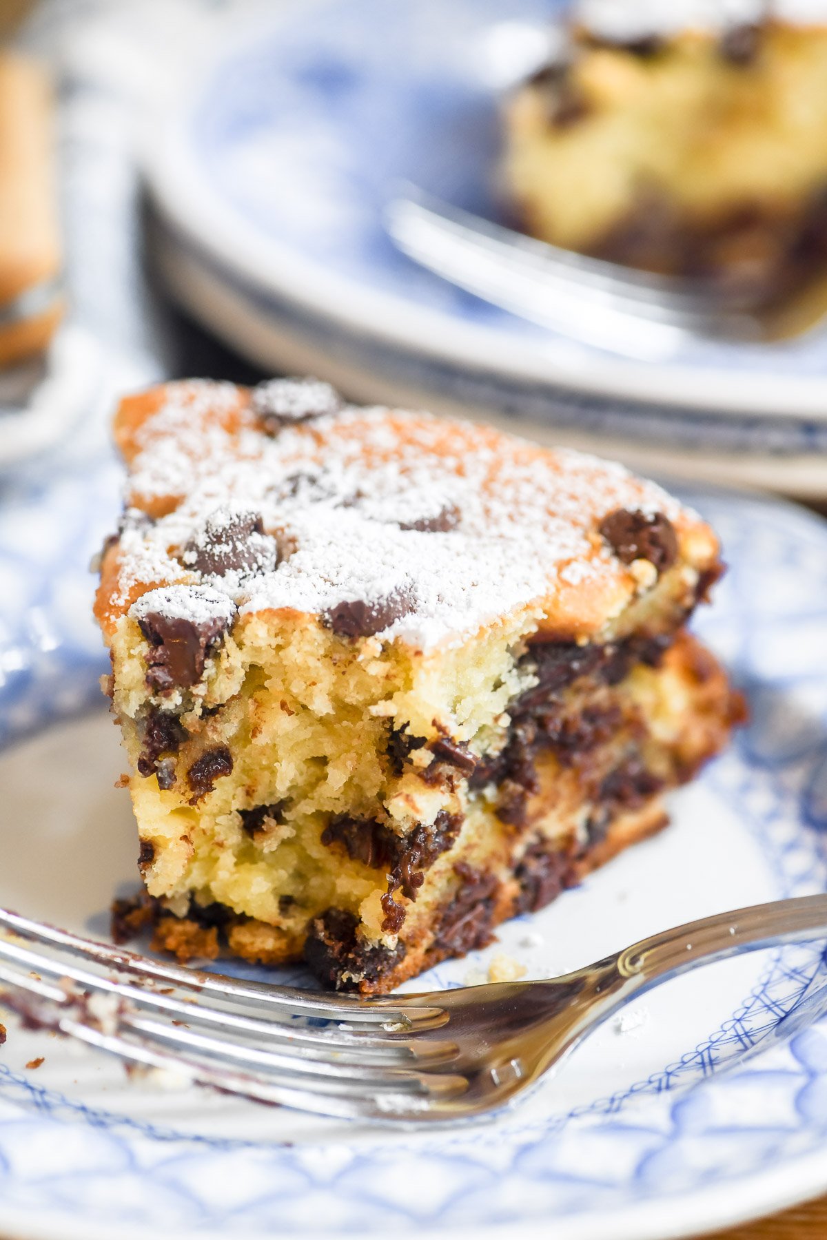 a slice of chocolate chip ricotta cake, with bite taken.