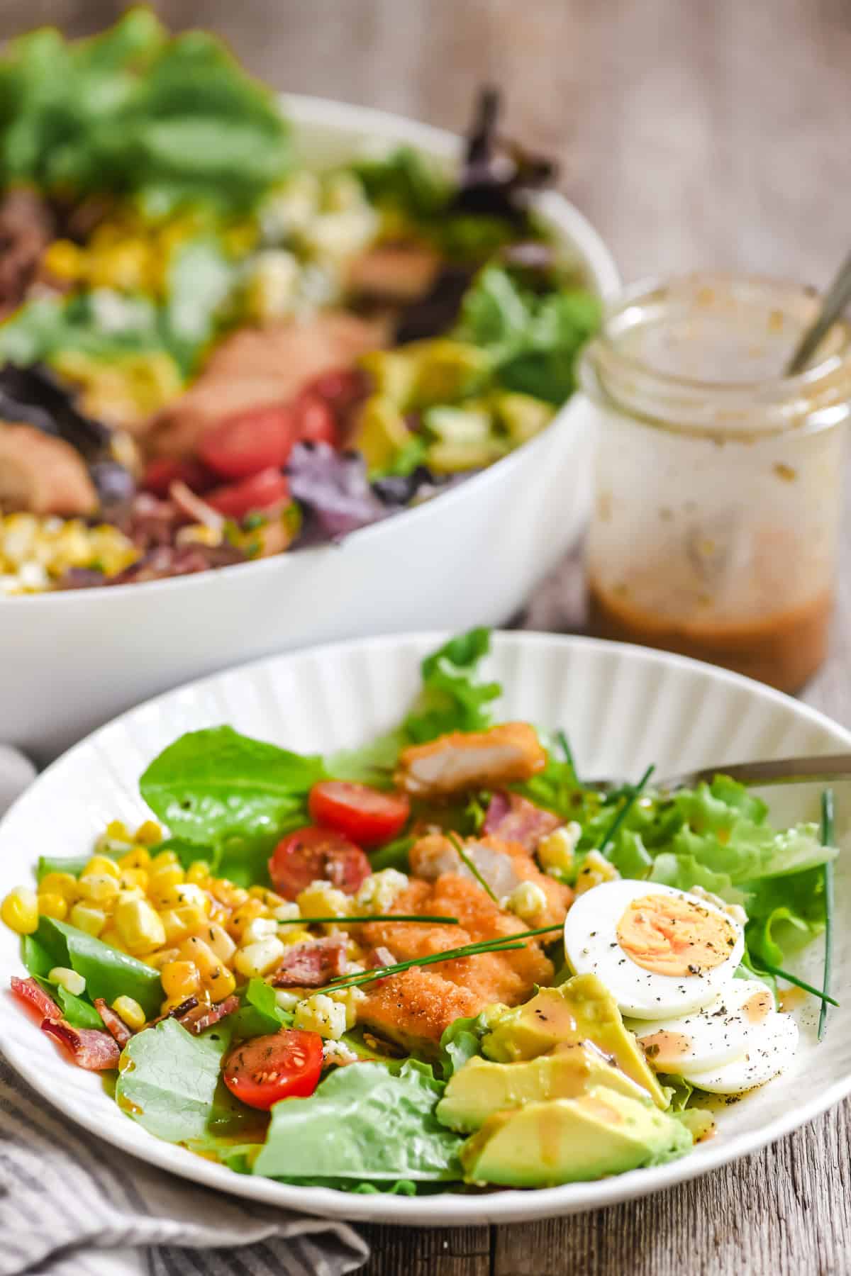 fried chicken cobb salad in a shallow white plate.