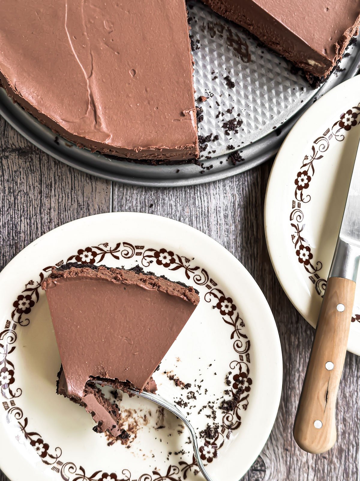 Overhead look at no bake chocolate cheesecake with piece on a plate.