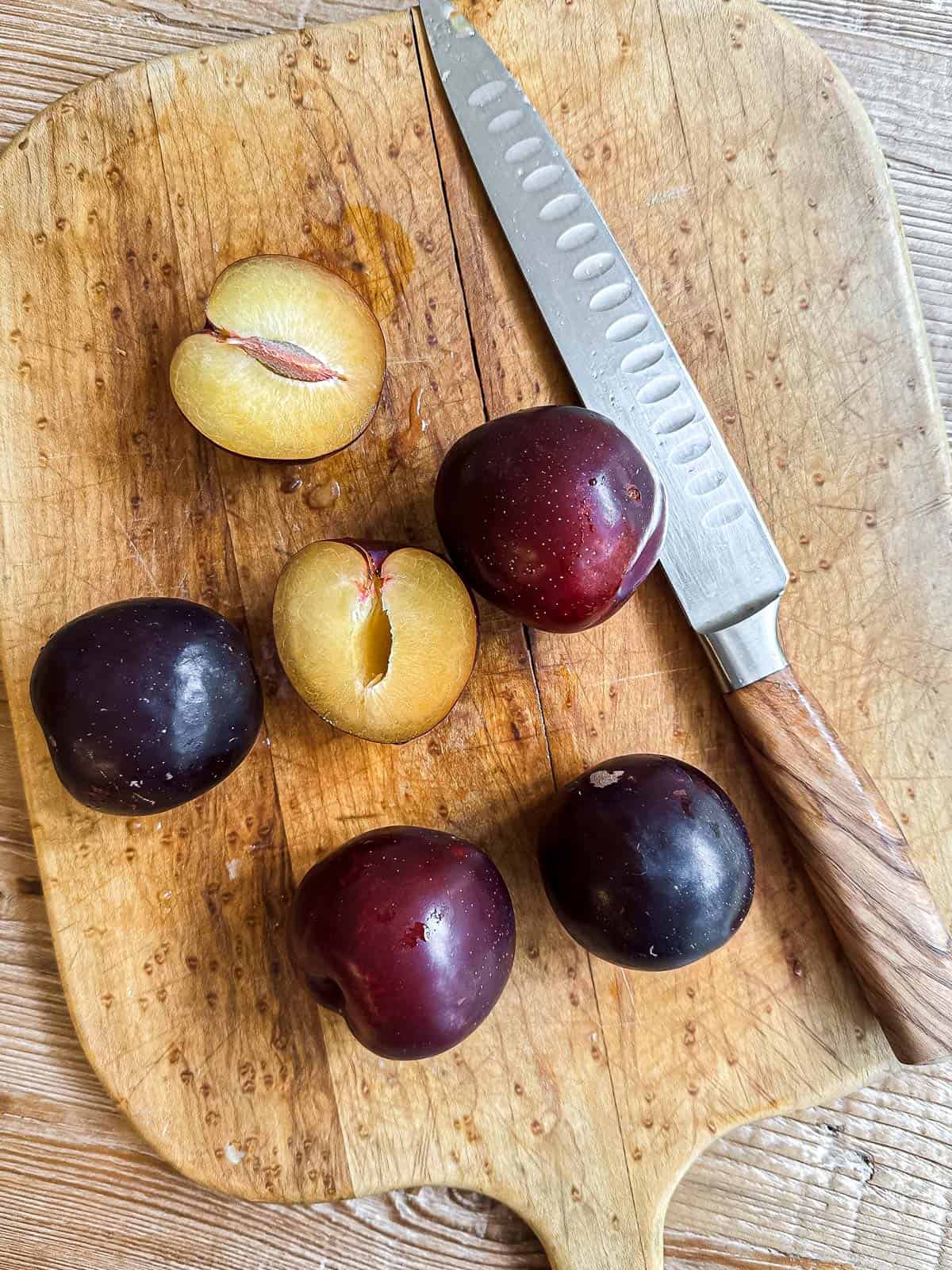 slicing plums on a cutting board