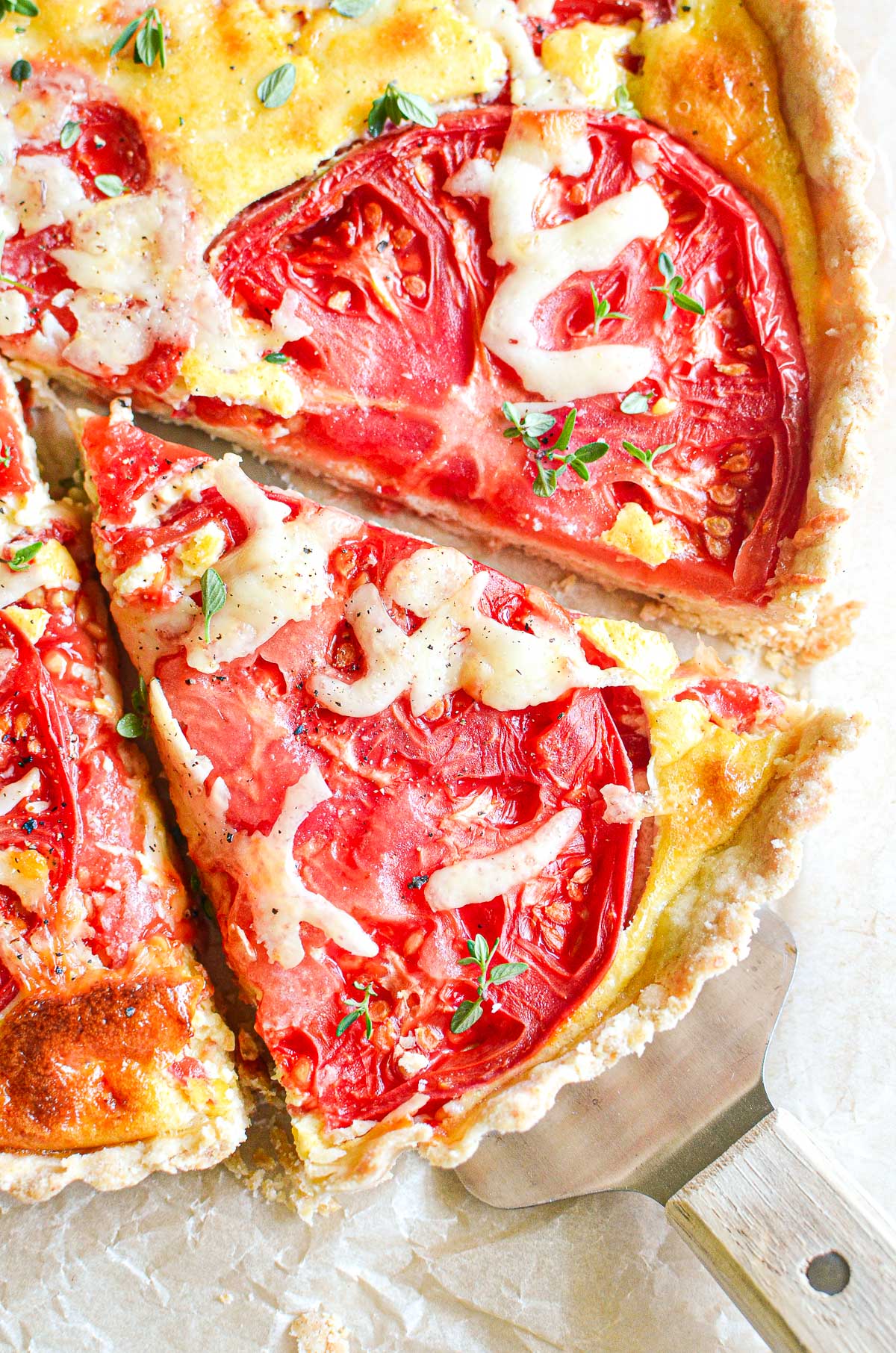 Slicing a tomato tart, topped with bits of fresh Thyme.