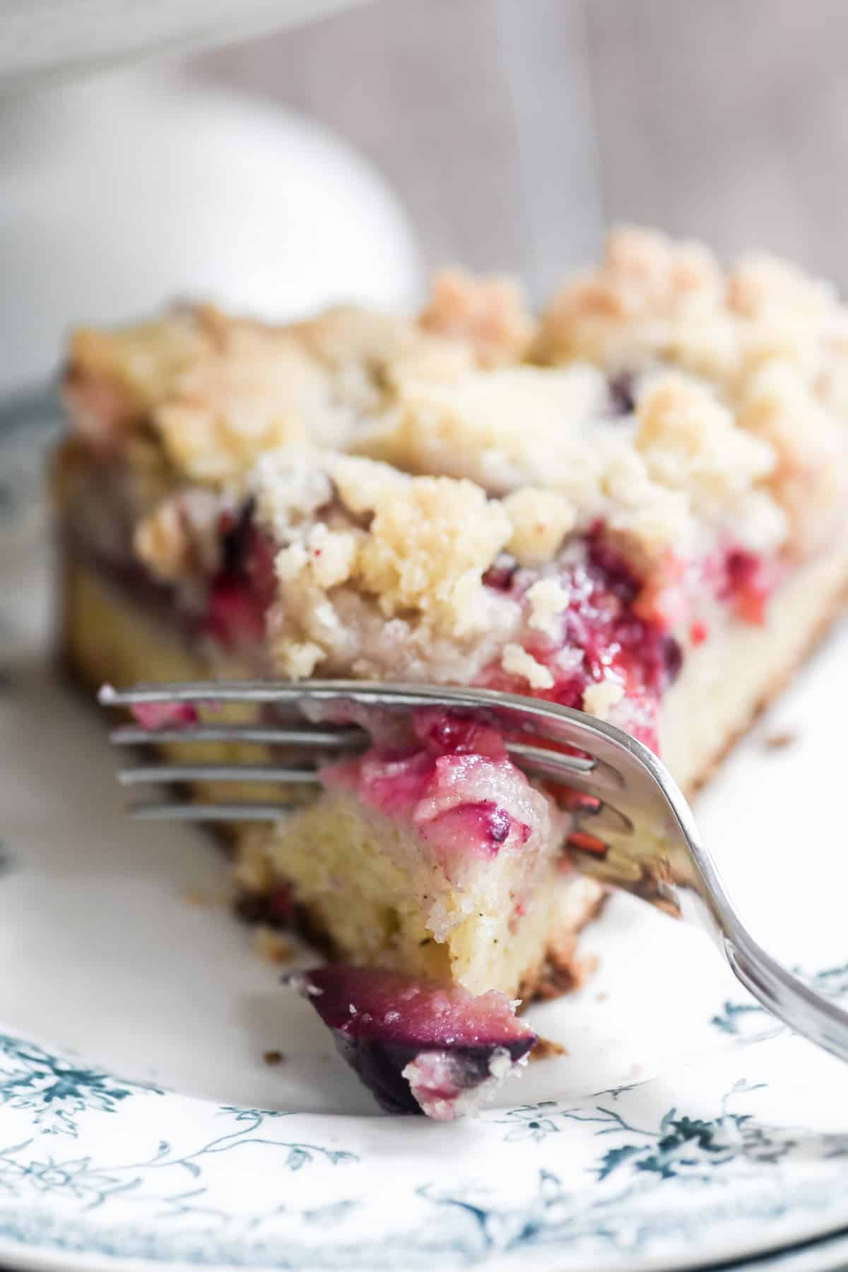 cardamom plum cake on a plate with fork.