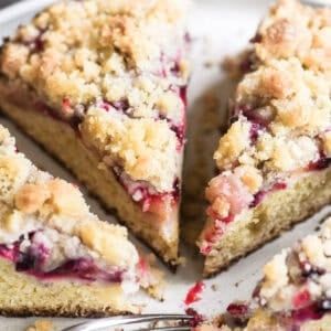 slices of cardamom plum cake on a cake stand.
