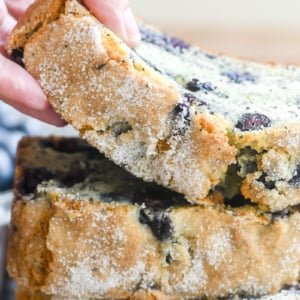 lifting a moist slice of blueberry poppy seed bread.