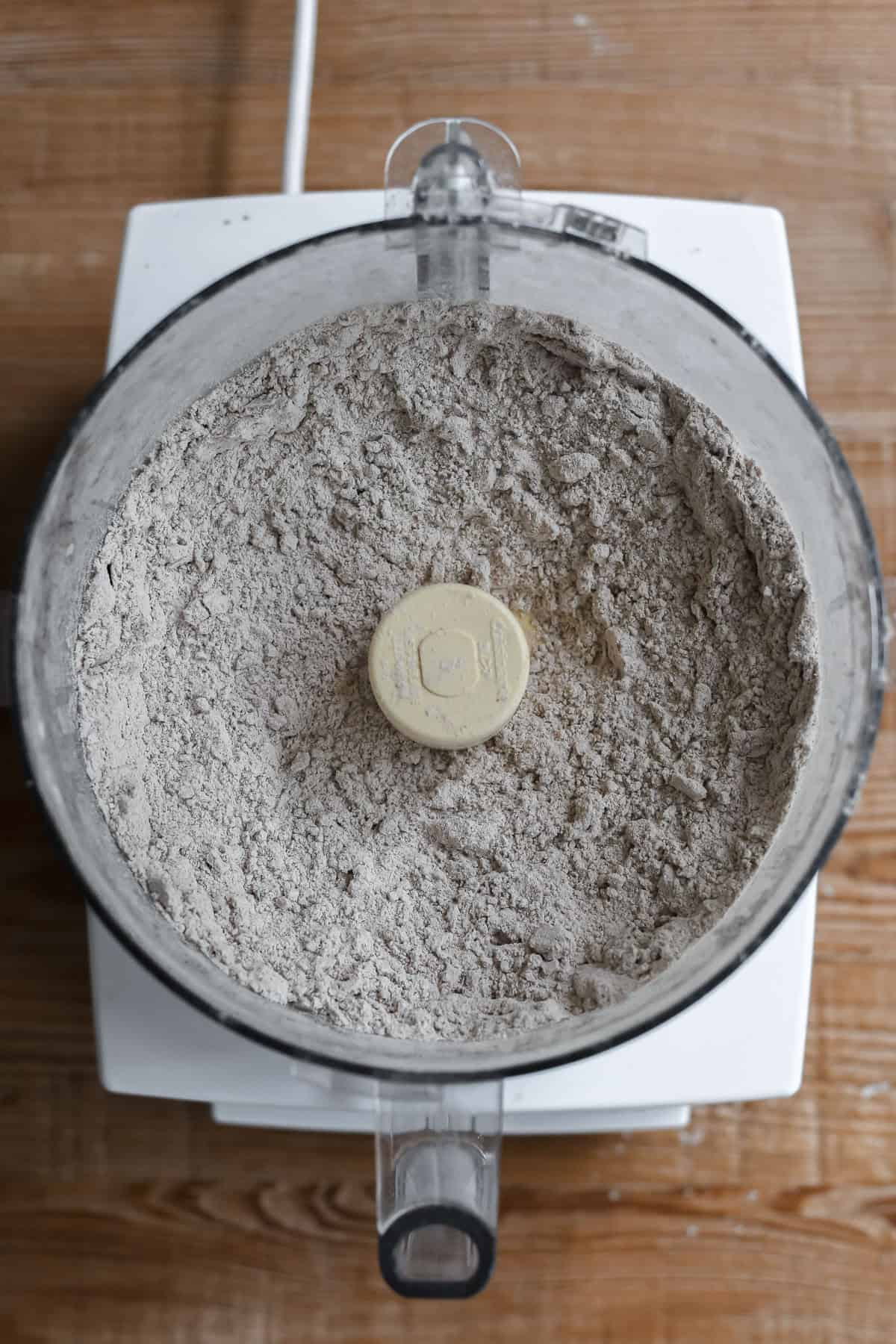 Blending dry ingredients for pumpernickel biscuits in a food processor.