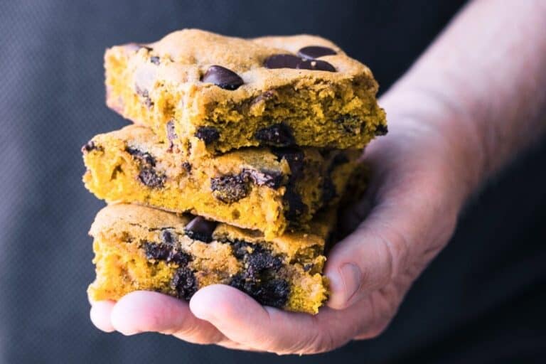 pumpkin chocolate chip blondies, stacked in a hand.