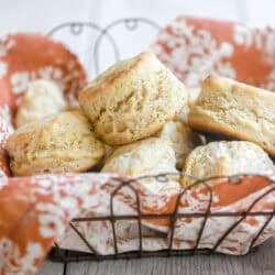 3 ingredient biscuits in a basket lined with an orange dinner napkin.
