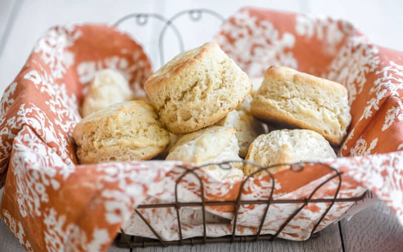 3 ingredient biscuits in a basket lined with an orange dinner napkin.