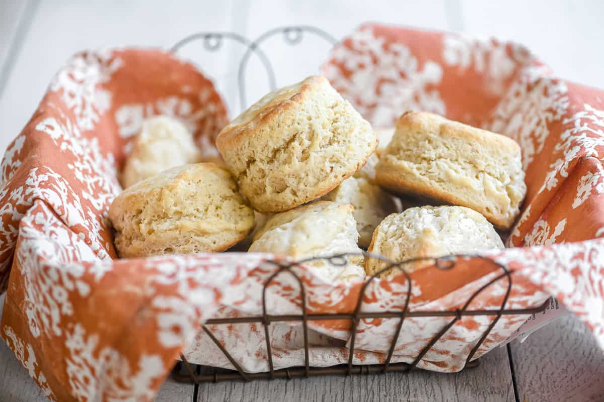3 ingredient biscuits in a basket lined with an orange dinner napkin.