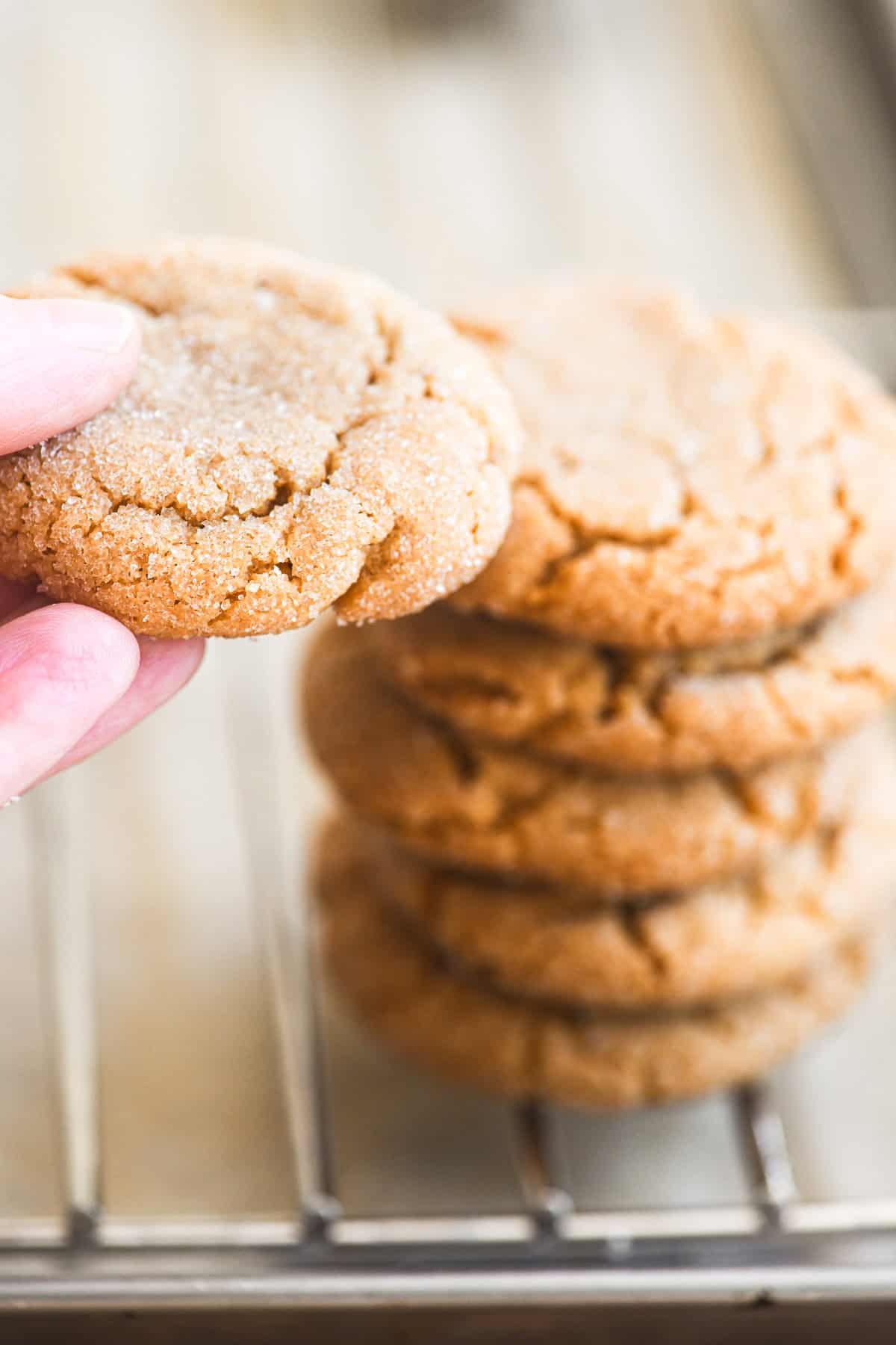 Taking a 3 ingredient peanut butter cookie from a stack.