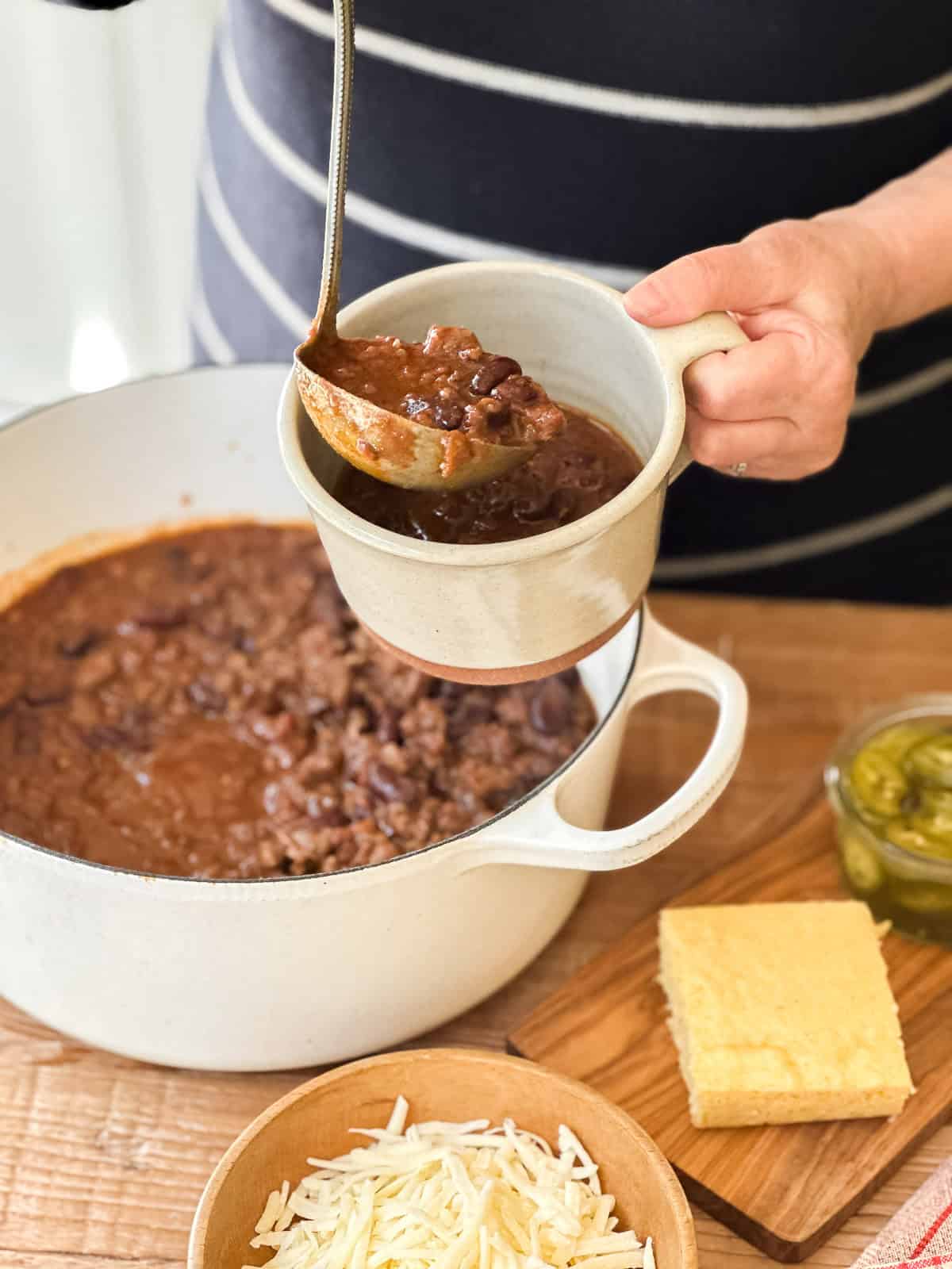 serving spiced chili from a Dutch oven.