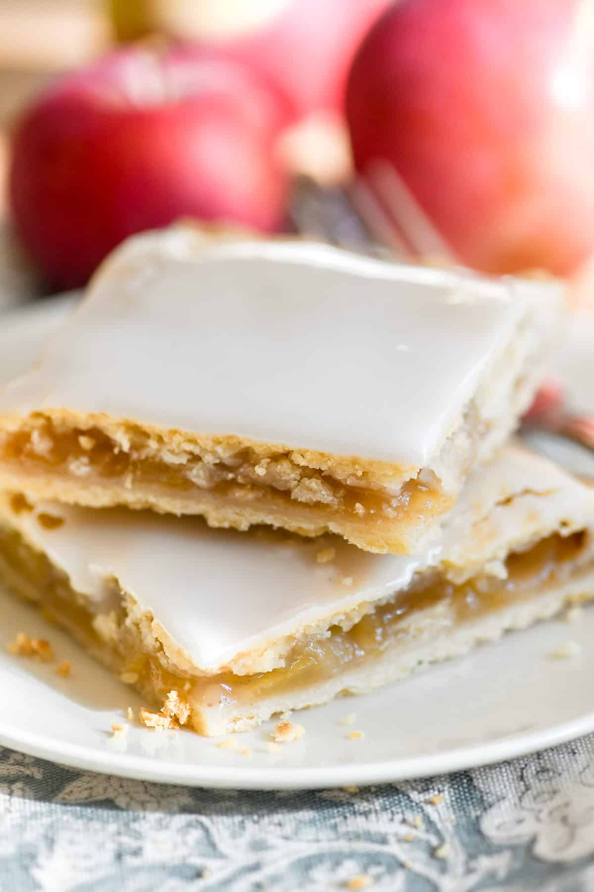 2 apple pie bars with sweet glaze, on a plate.