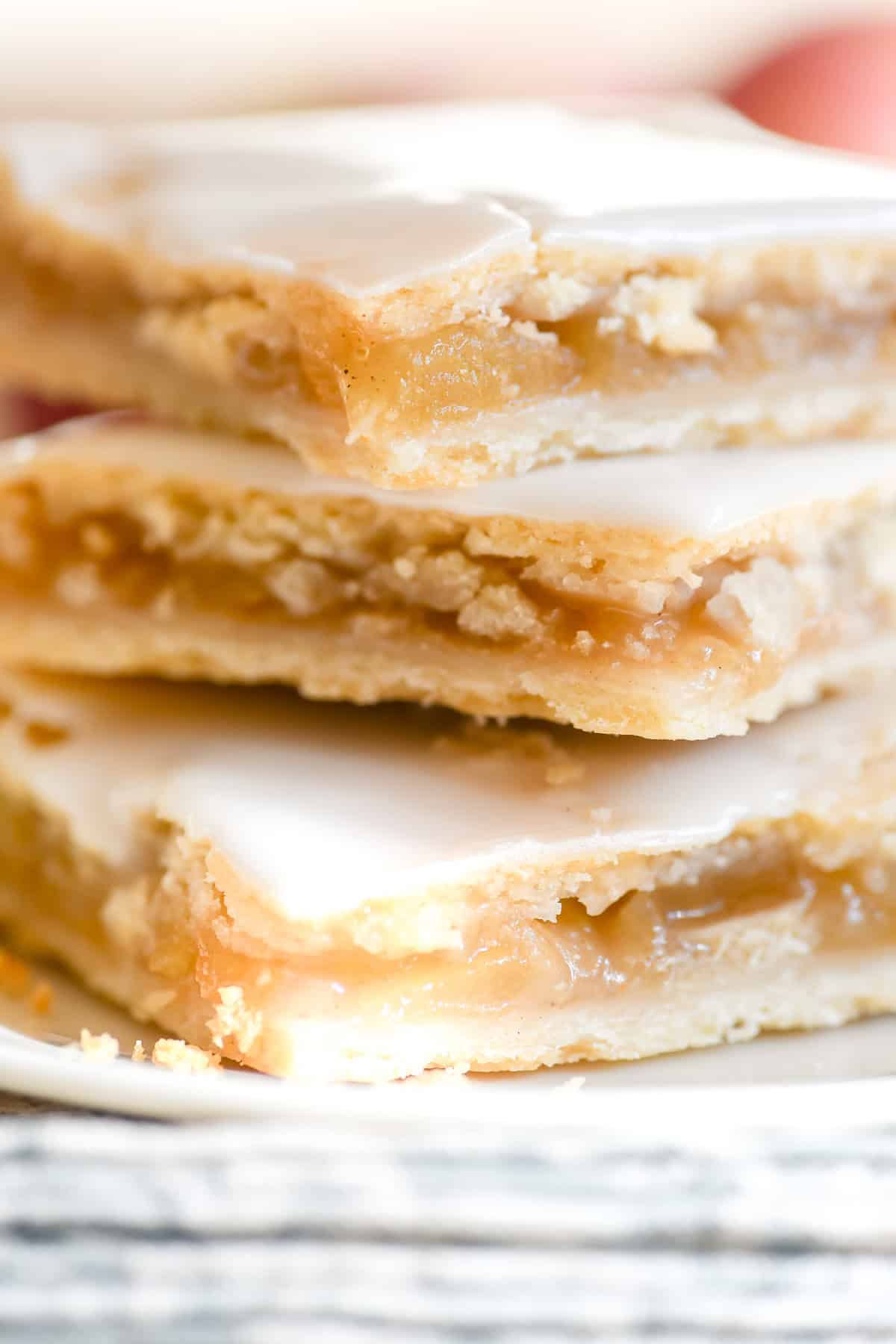 close look at a stack of apple pie bars with juicy apple pie filling.
