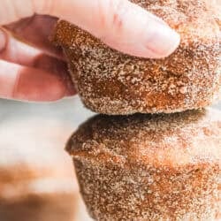 Taking a cinnamon toast muffin from a stack of muffins.
