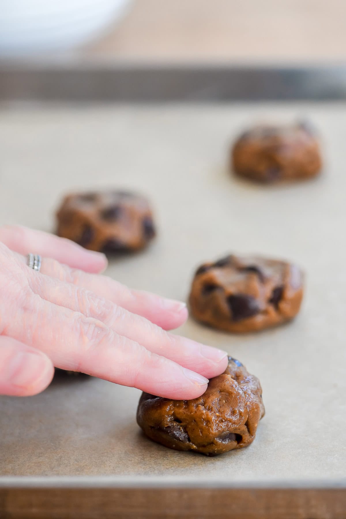 flattening balls of flourless almond butter chocolate chip cookie dough.