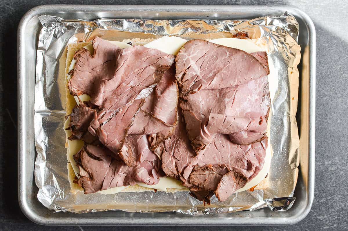 Sliced roast beef on bottom bread for French Dip Sliders