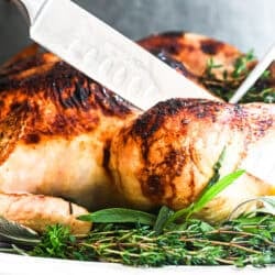 Carving roast chicken with lemon and herbs.